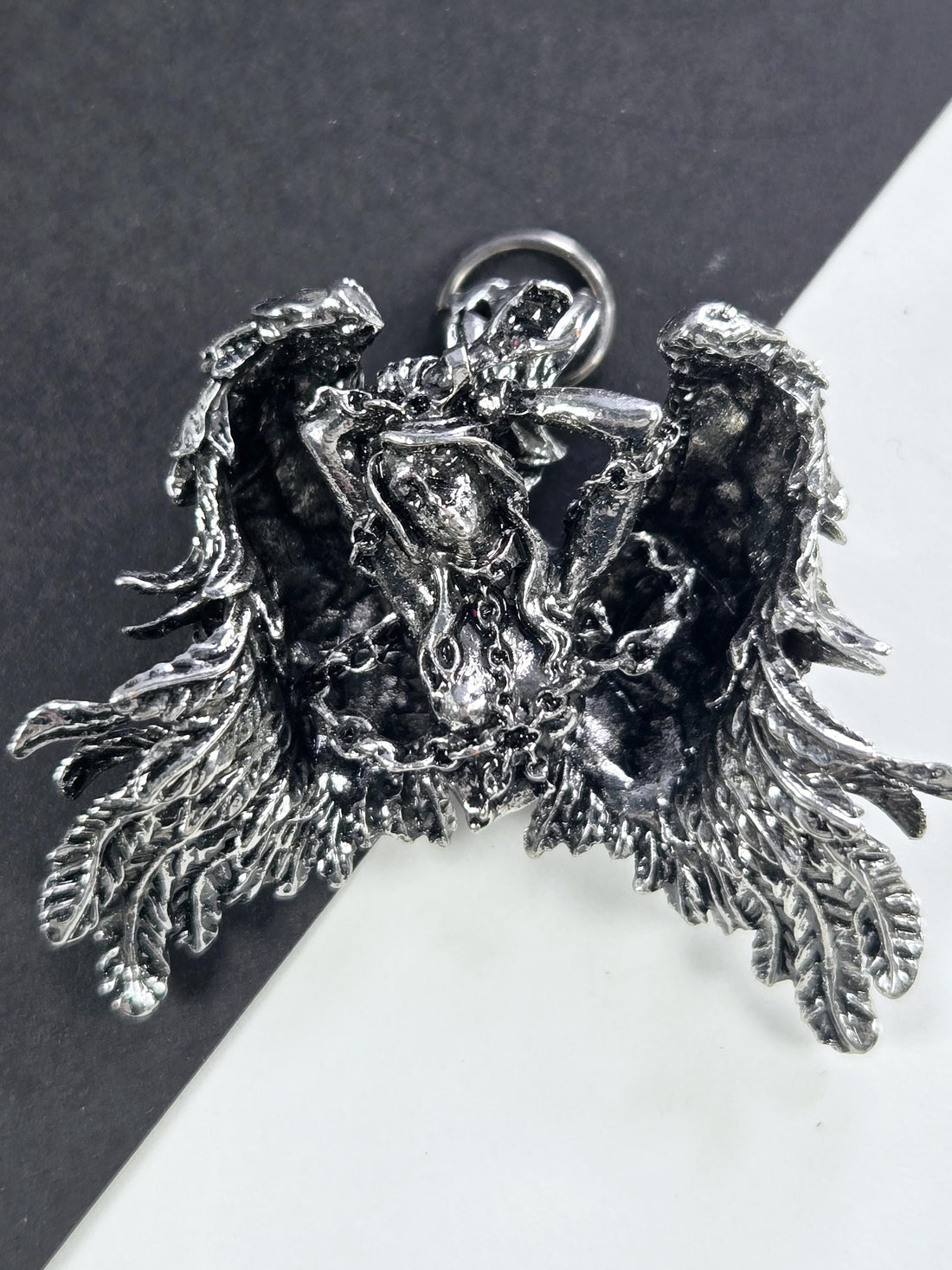 A detailed, intricate metal sculpture of a dragon-like creature with sharp teeth and claws, set against a contrasting background.