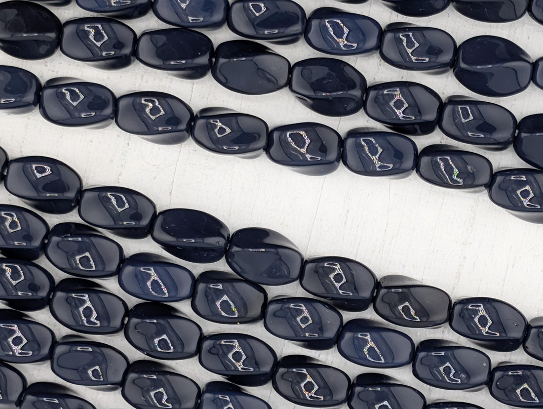 a collection of dark blue beads arranged in a row, creating a visually striking and cohesive display.
