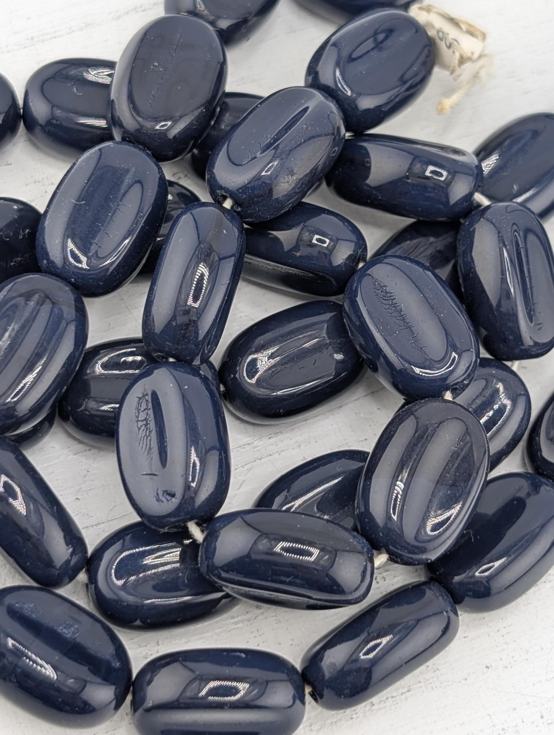 a collection of dark blue beads arranged in a pattern, with some of the beads overlapping each other.