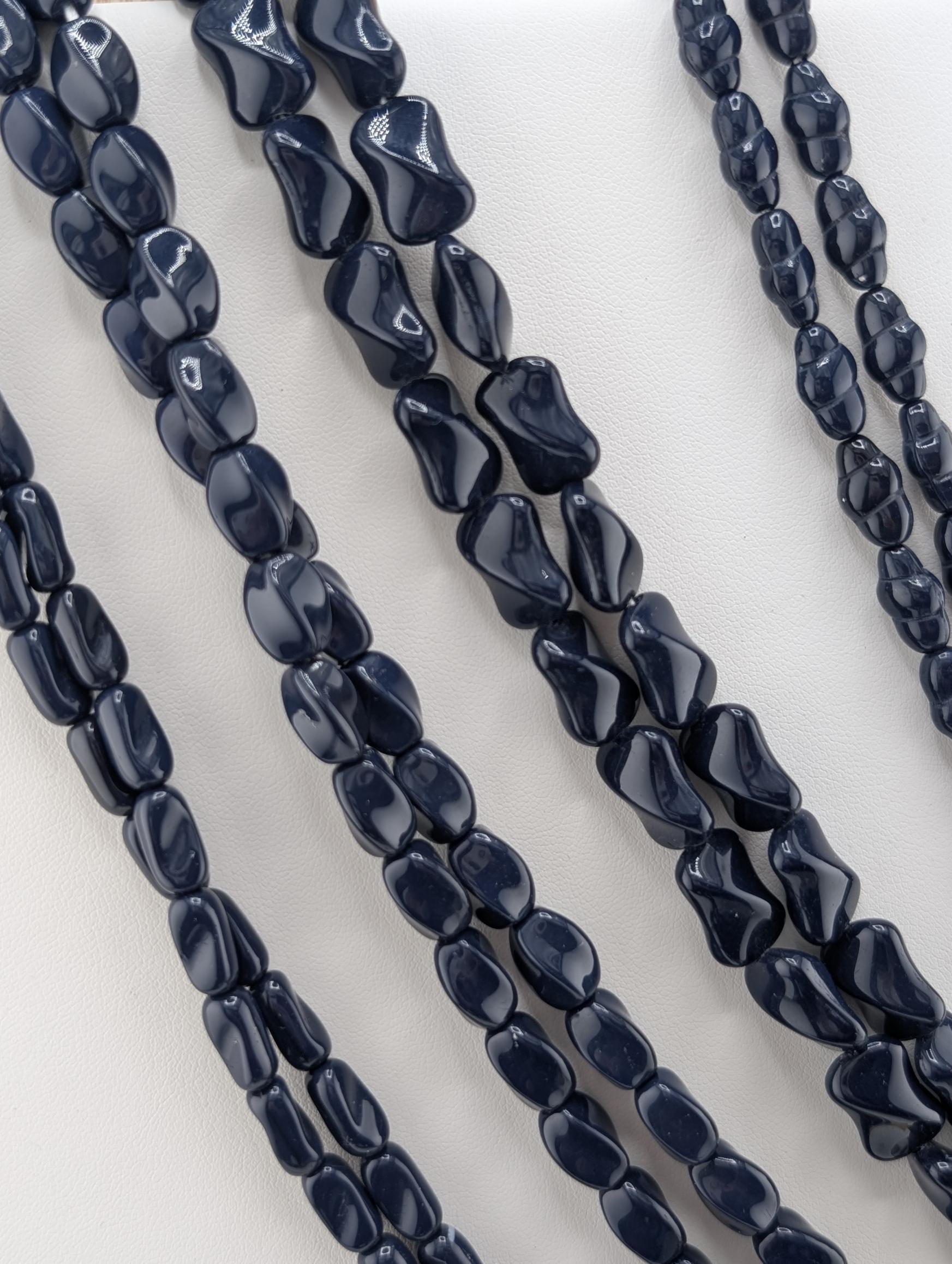 a collection of dark blue beads arranged in a row, creating a visually striking and cohesive display.