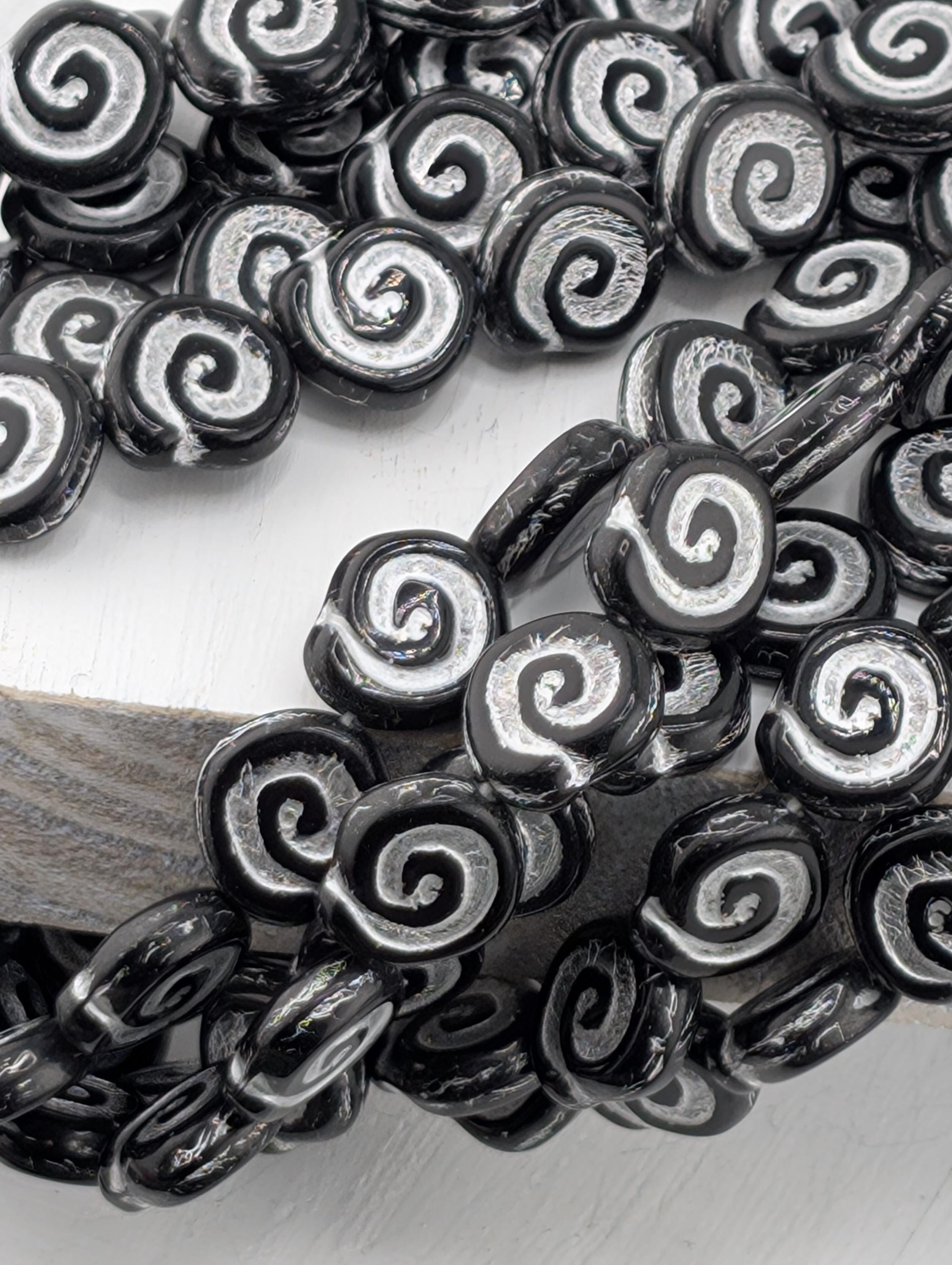 a close-up view of numerous black and white spiral beads arranged in a pattern.