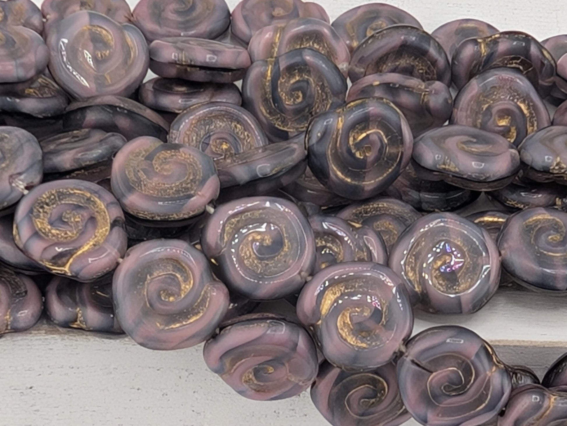 a collection of purple and gold spiral beads arranged in a visually appealing manner.