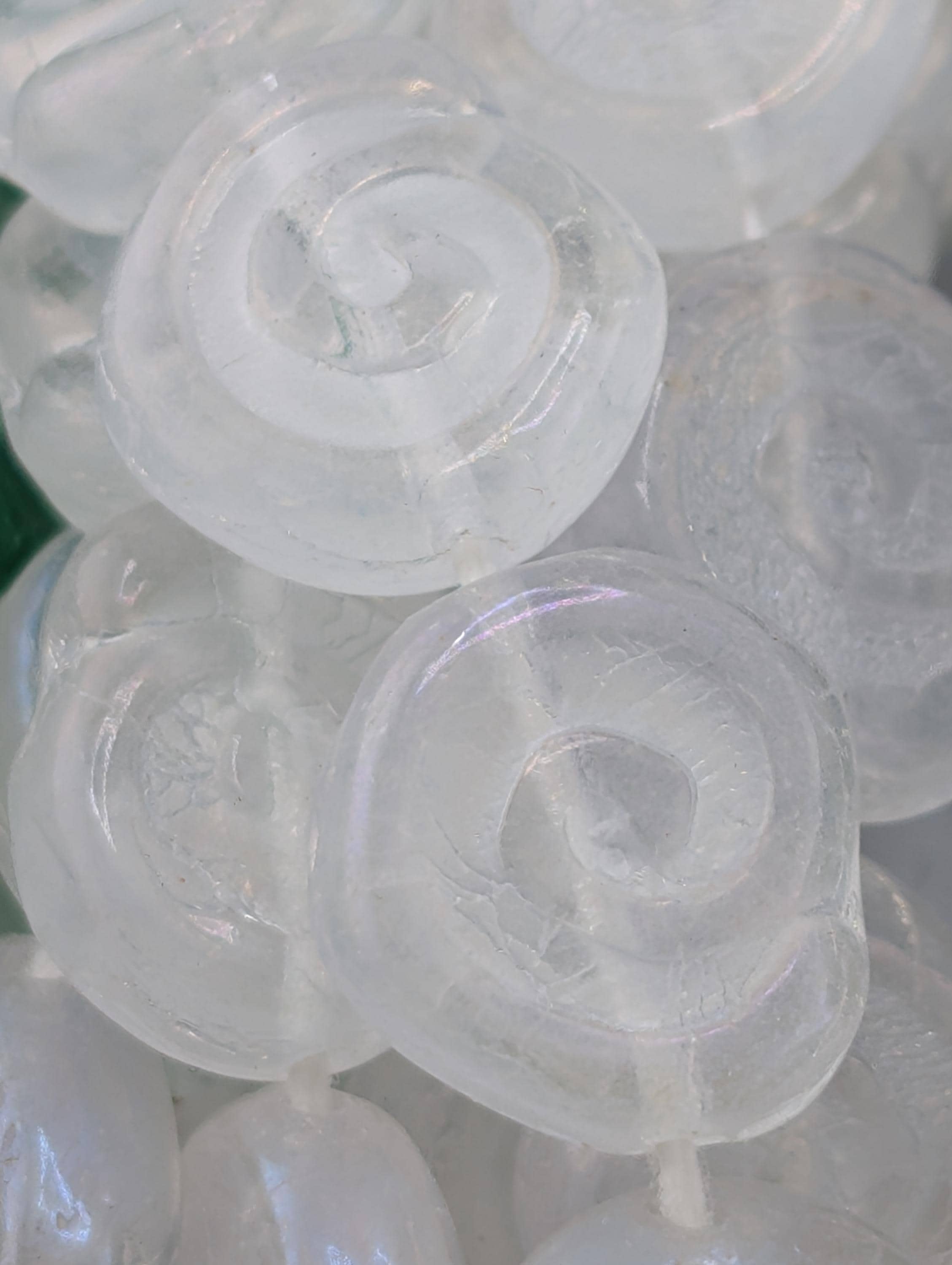 a close-up view of numerous white, spiral-shaped objects, possibly beads or candies, arranged in a visually appealing manner.