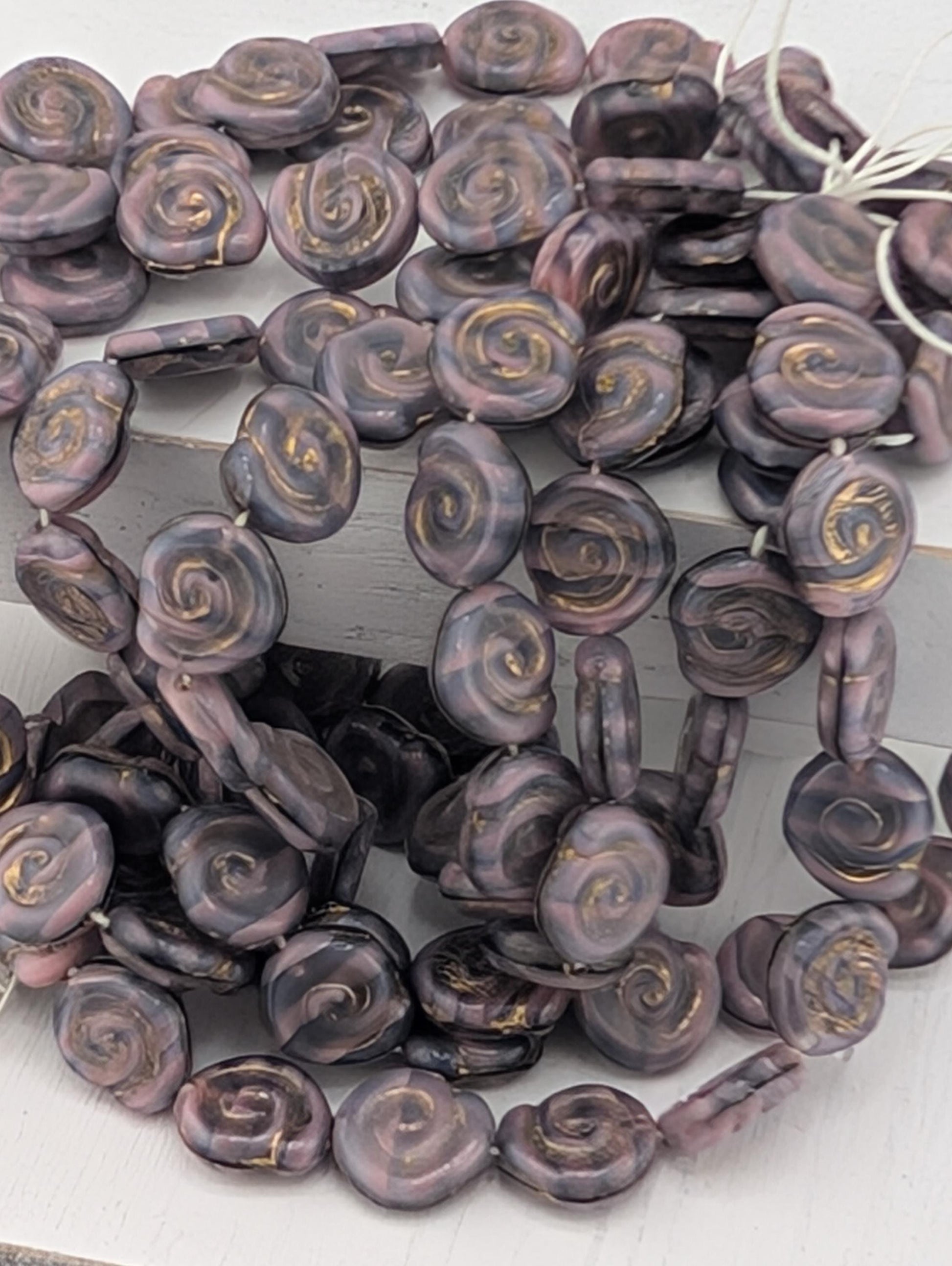 a collection of purple and gold spiral beads arranged in a circular pattern.