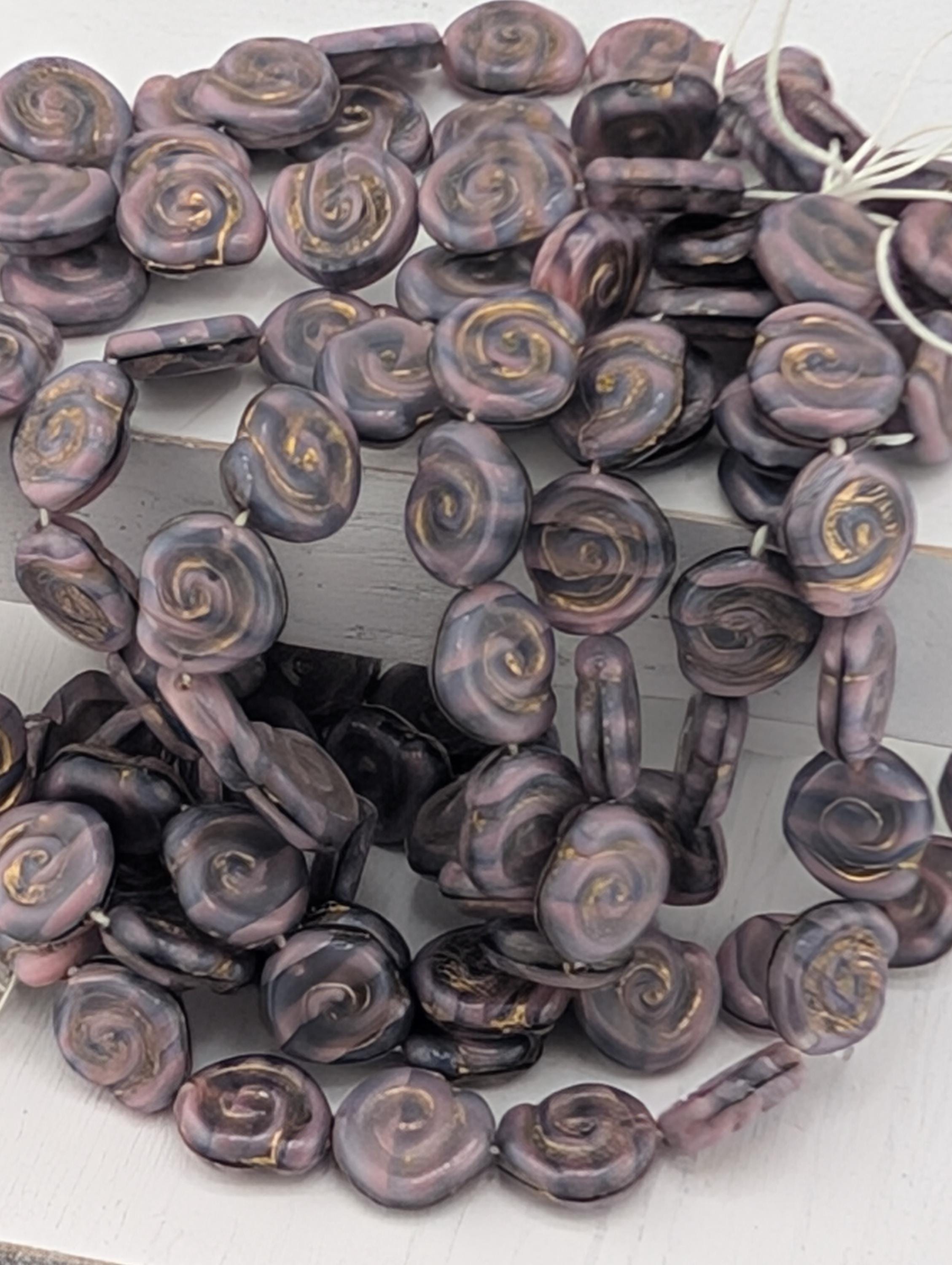 a collection of purple and gold spiral beads arranged in a circular pattern.