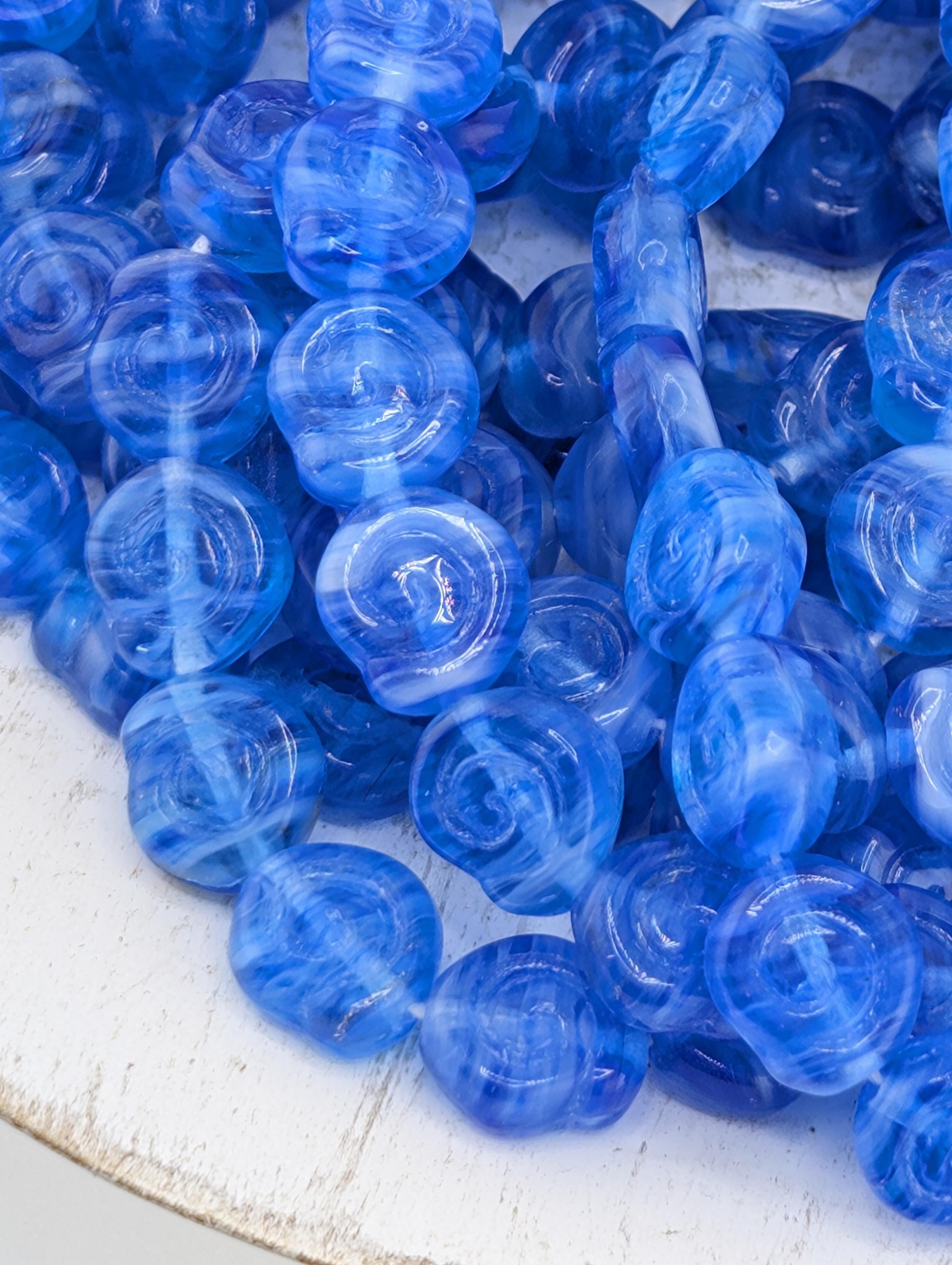 a close-up view of numerous blue glass beads arranged in a pile.