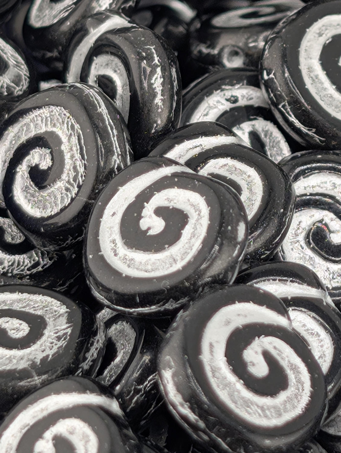 a close-up view of numerous black and white spiral beads arranged in a pattern.
