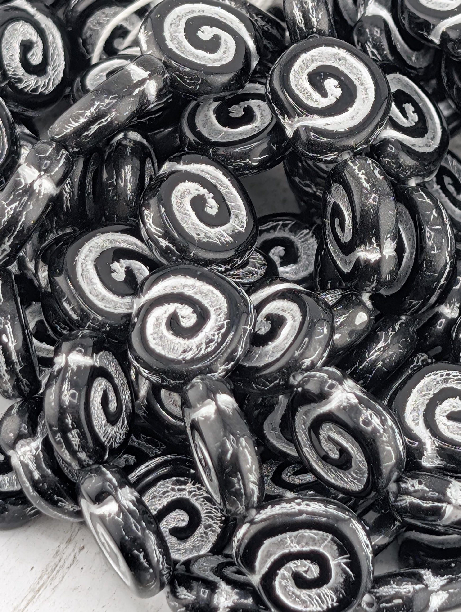 a close-up view of a pile of black and white spiral beads, with their intricate patterns and textures clearly visible.