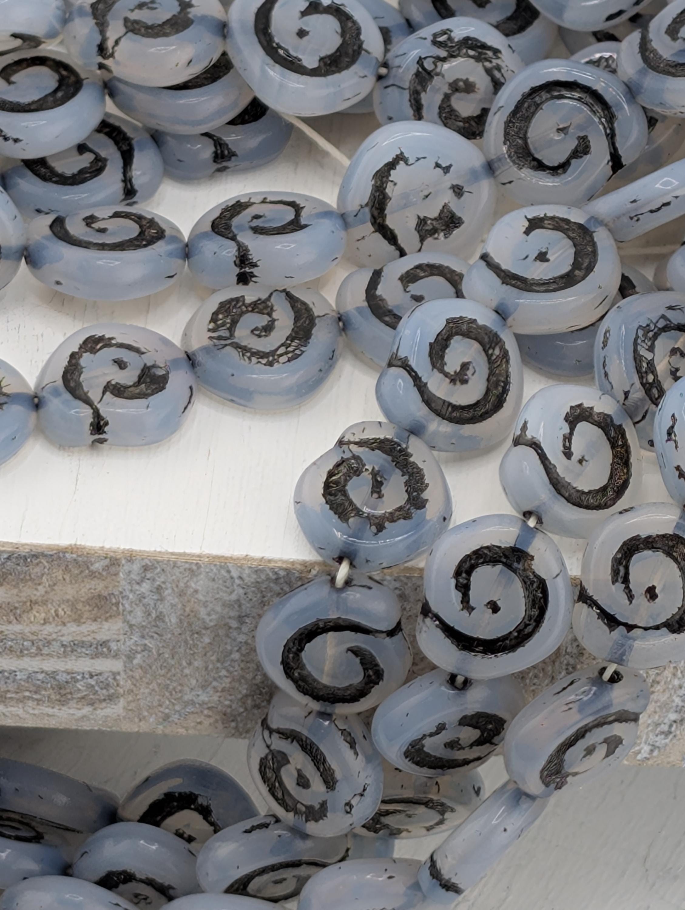 a collection of blue and black spiral beads arranged in a pattern.