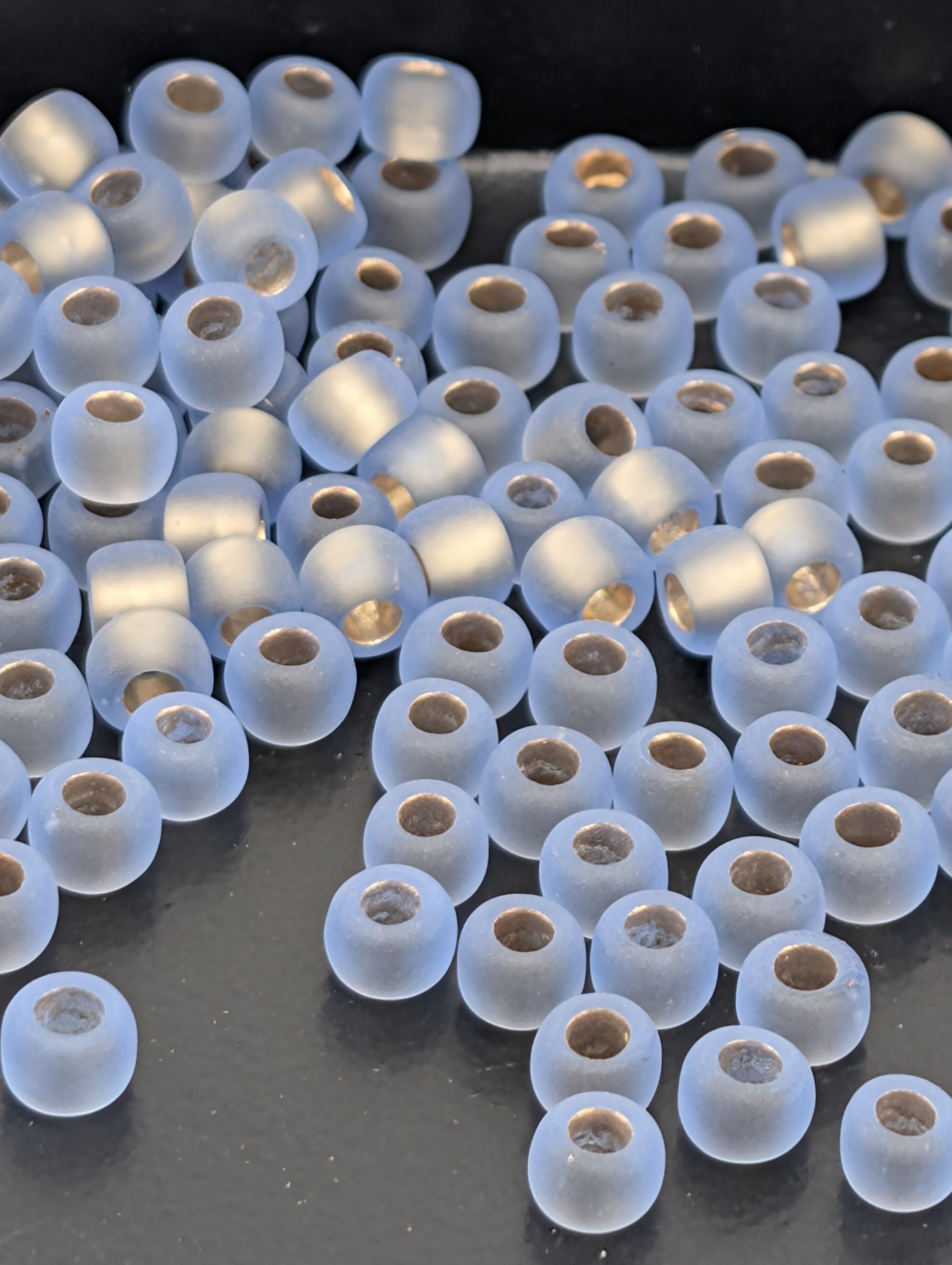 a collection of small, clear beads scattered on a dark surface.