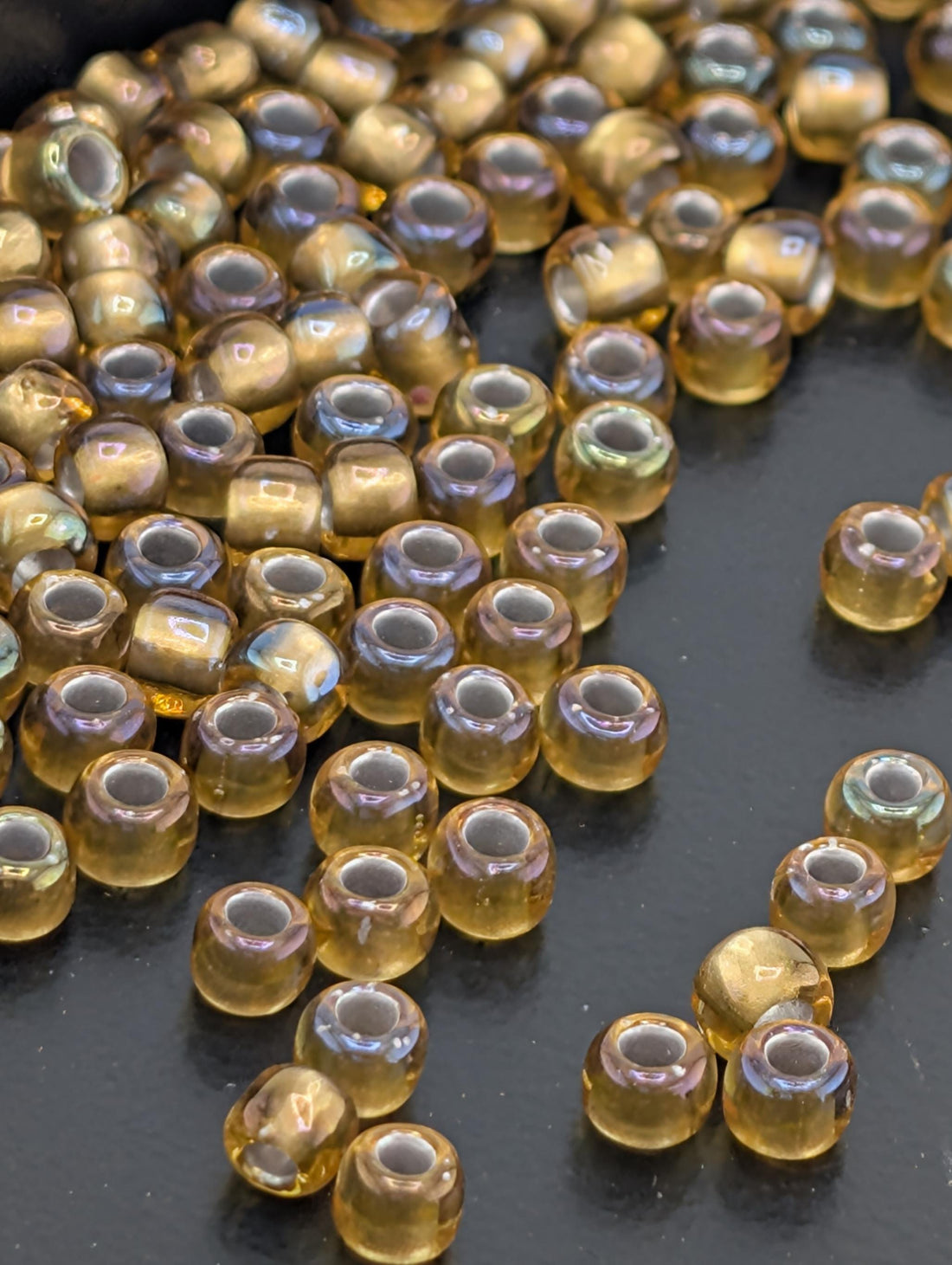 a collection of small, round, yellow beads scattered on a dark surface.