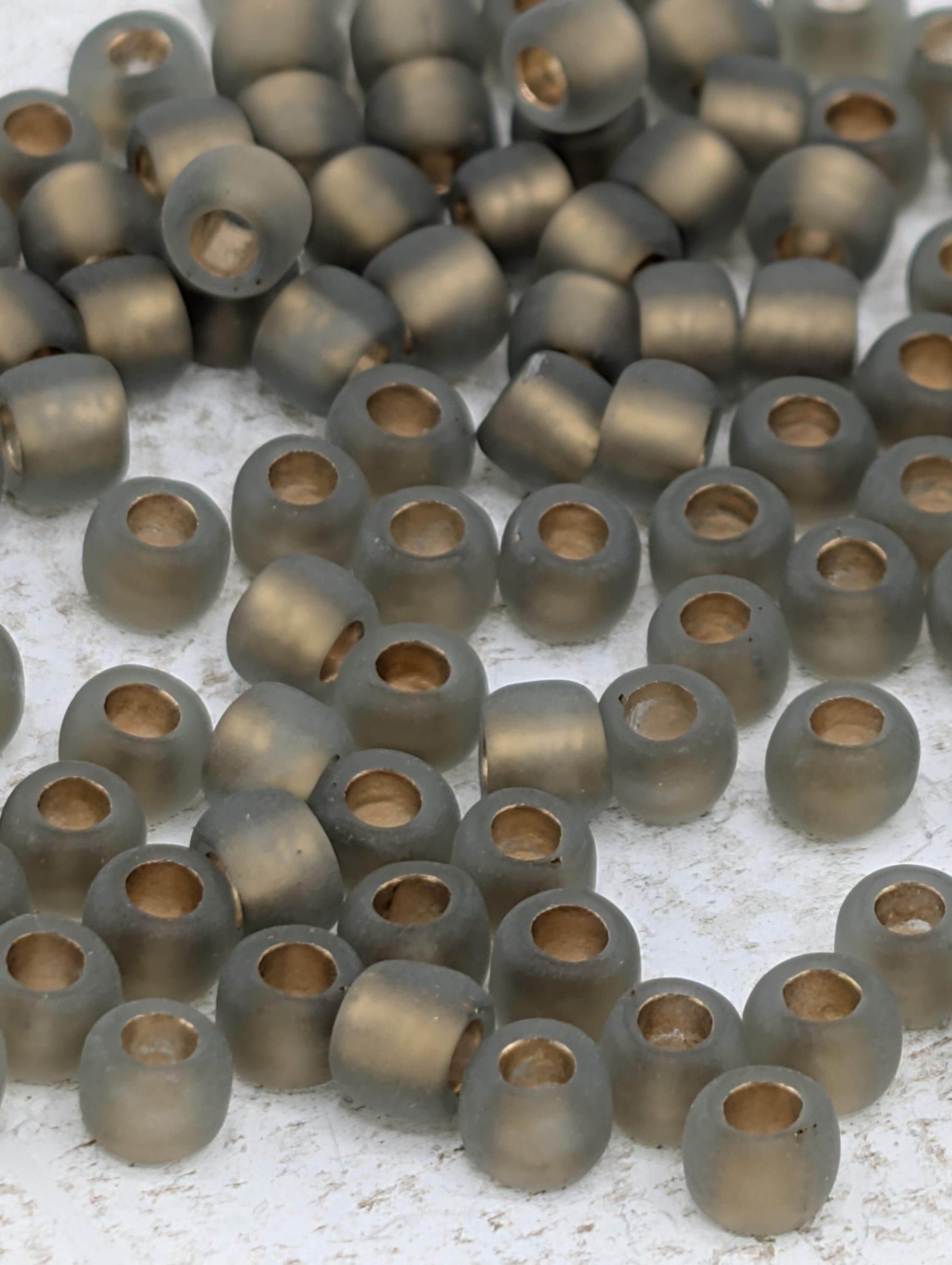 a collection of small, round beads in various shades of gray, scattered across a white surface.