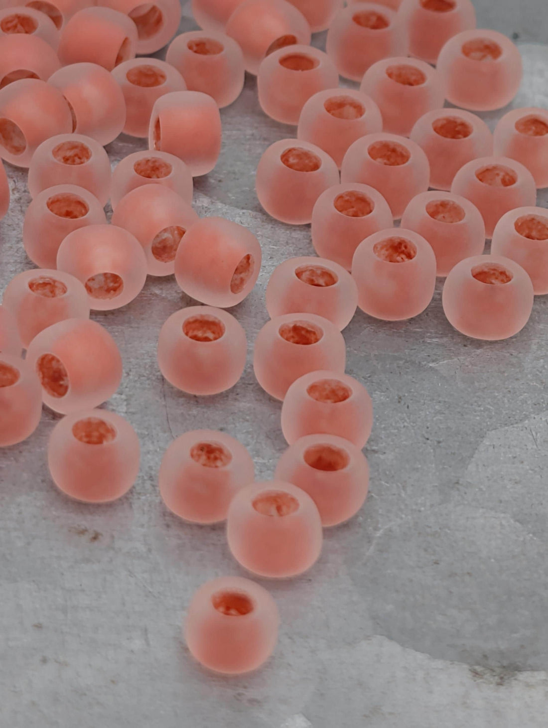a collection of small, round, pink beads scattered on a surface.