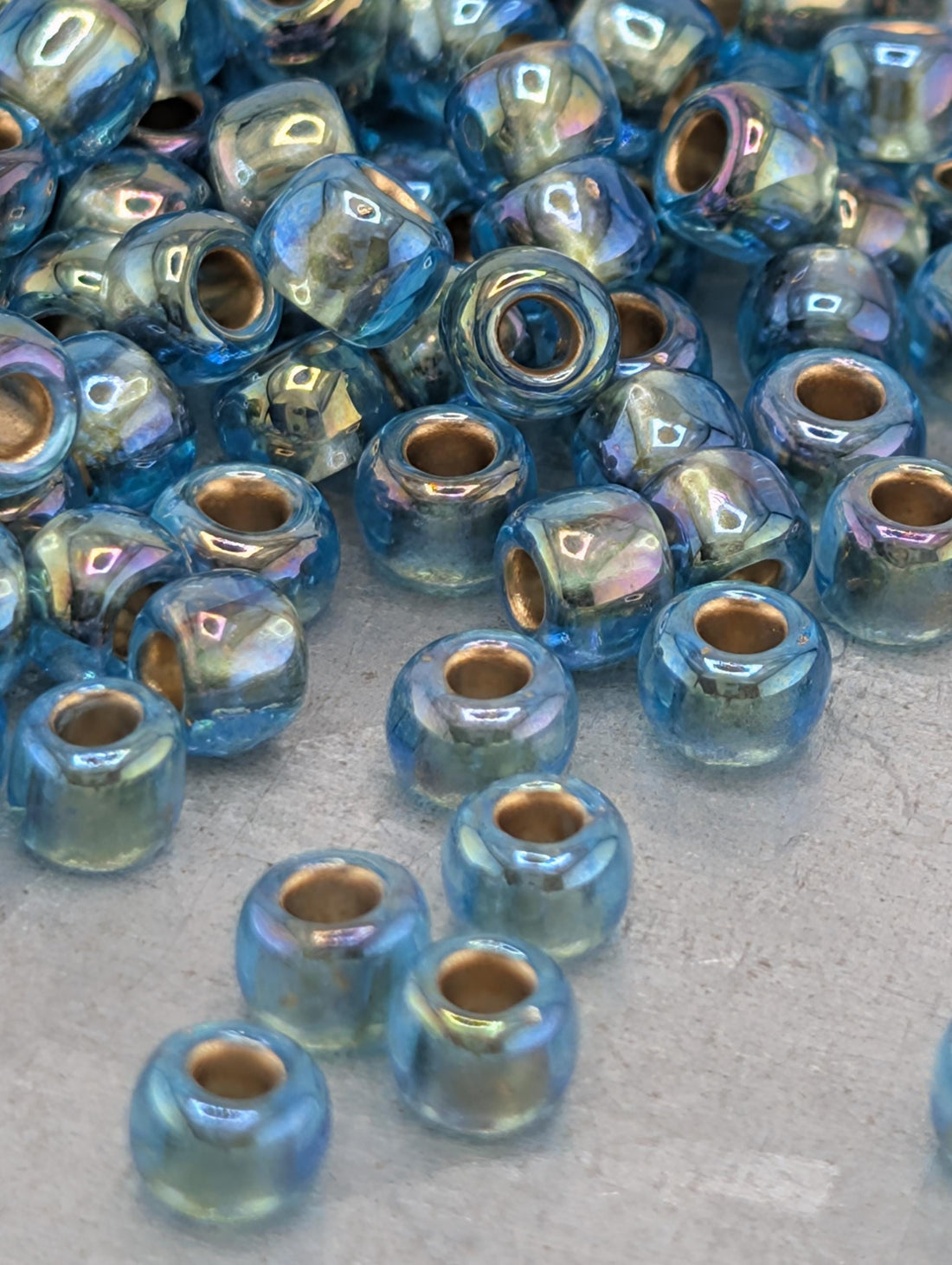 a collection of blue and green glass beads scattered on a surface.