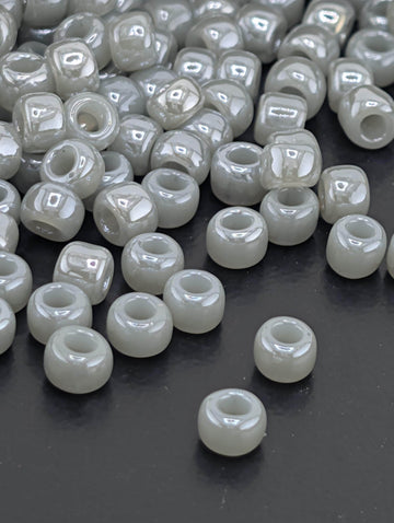 a collection of small, white beads scattered on a dark surface.