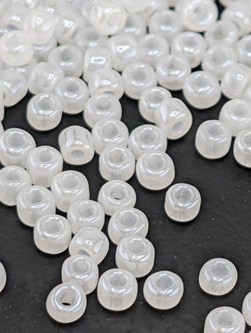 a collection of small, clear beads scattered on a dark surface.