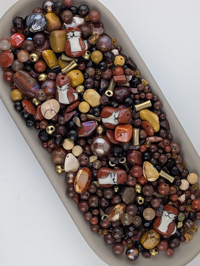 a large bowl filled with various beads and beads, including some that appear to be animal-shaped beads.