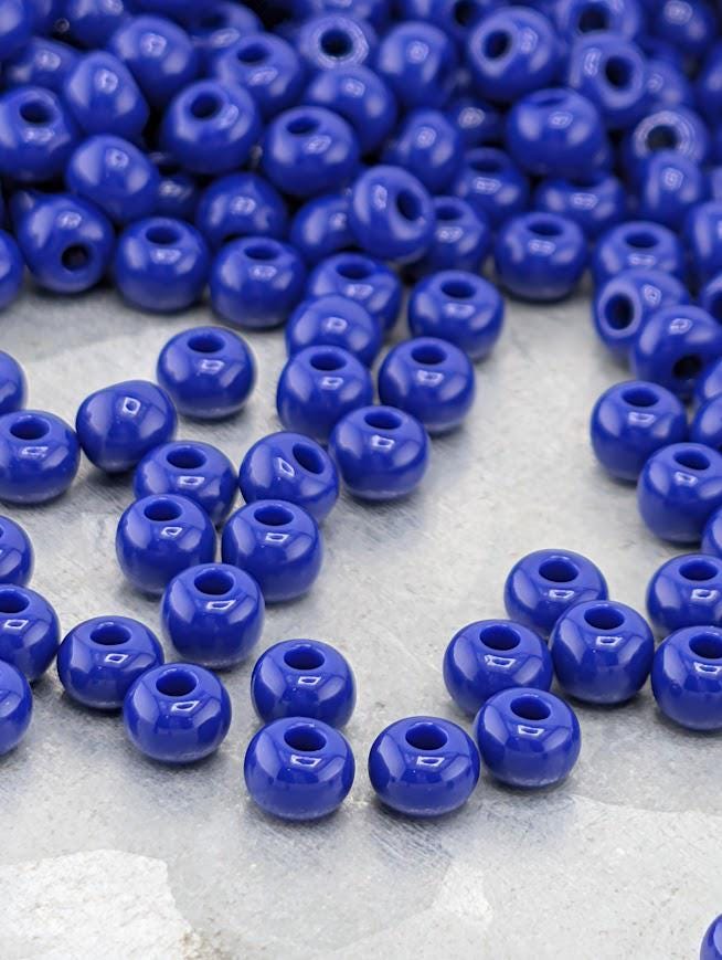 A collection of clear glass tubes filled with various shades of blue beads, arranged in a row.