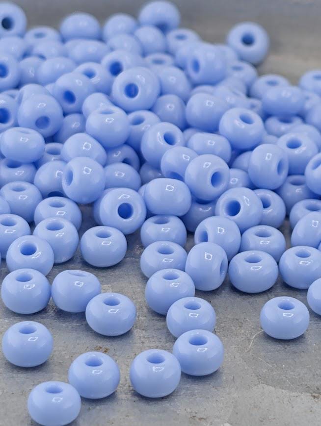 a collection of small, round, blue beads scattered on a surface.