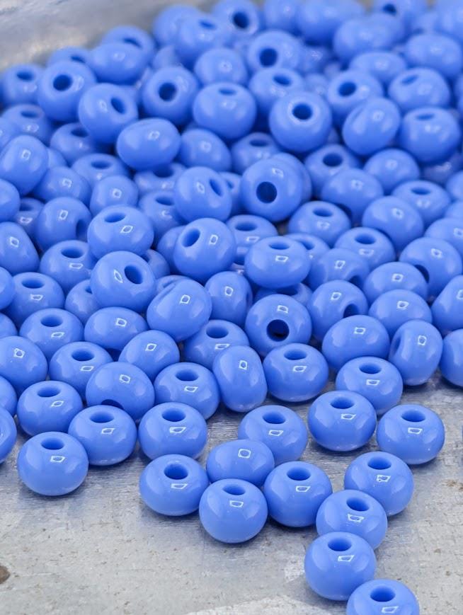 a large pile of blue beads scattered on a surface.
