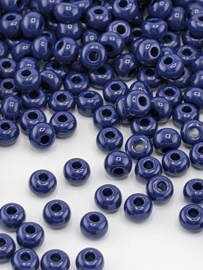 a large number of small, round, blue beads scattered across a white background.
