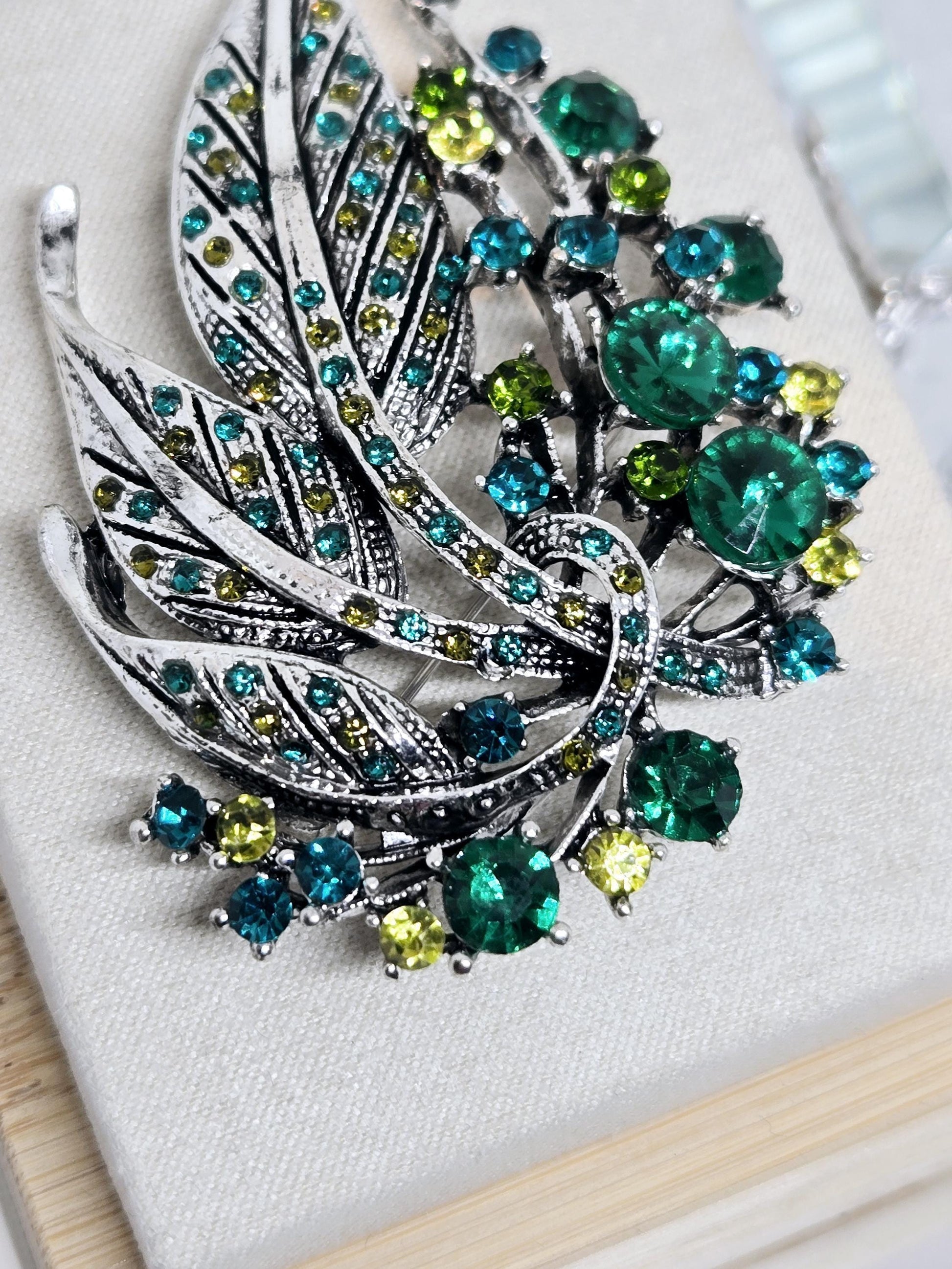 Silver Feather Brooch: Blue Topaz and Emerald Accents