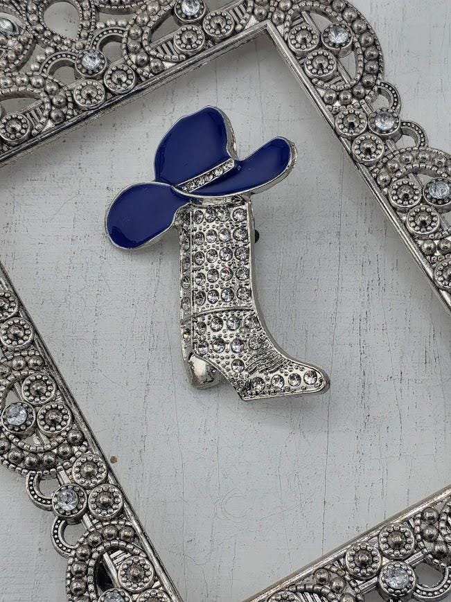 A decorative silver frame with a blue cowboy hat and silver boot embellished with rhinestones.