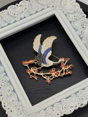 A decorative white frame with a black background, containing a framed image of a bird with blue and white feathers and red flowers.