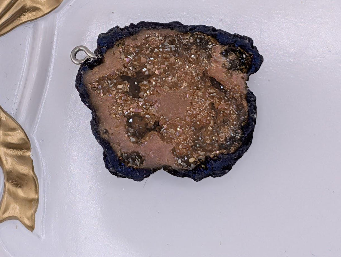 a close-up view of a piece of rock with a dark, rough surface, possibly a mineral or gemstone, set against a white background.