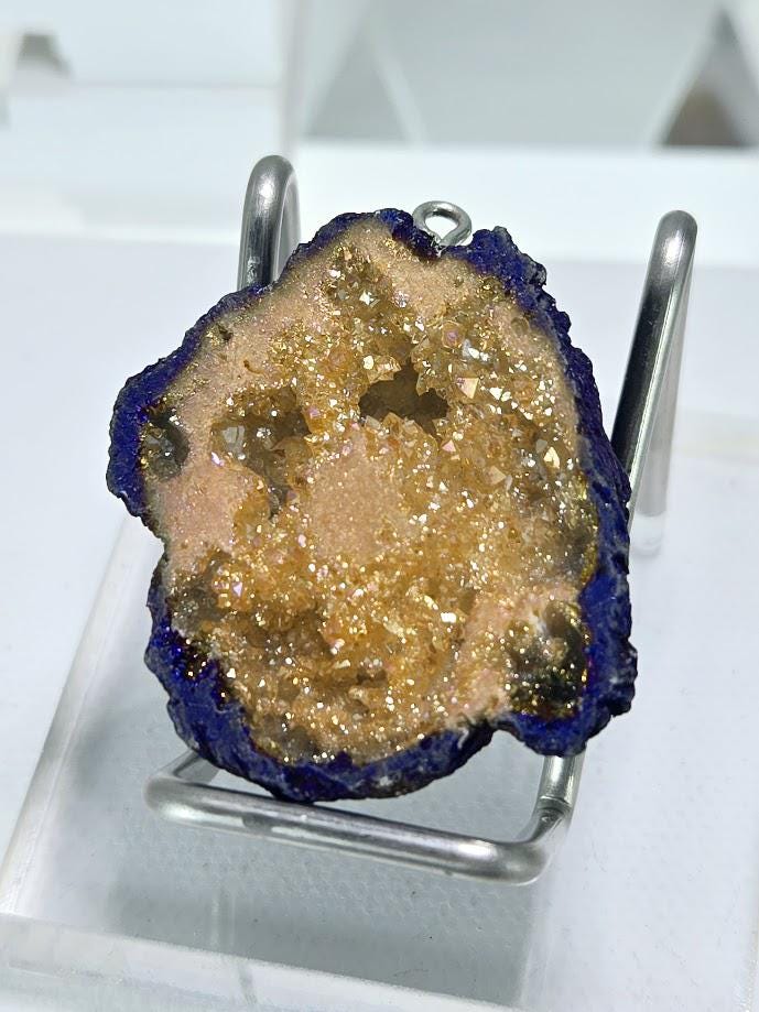 a close-up view of a piece of rock with a dark, rough surface, possibly a mineral or gemstone, set against a white background.