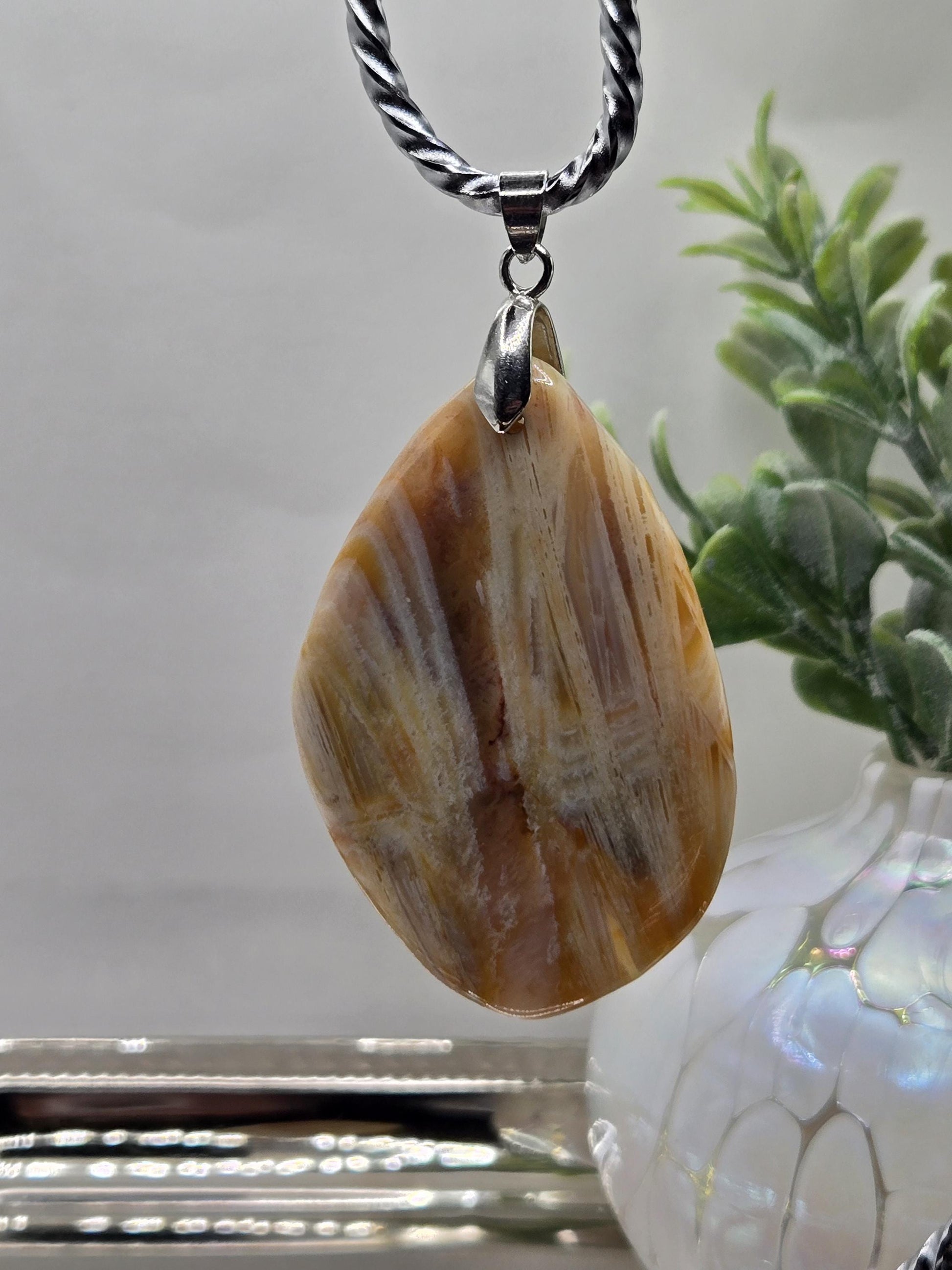 A pendant made of a large, irregularly shaped stone with a unique pattern, hanging from a metal chain.