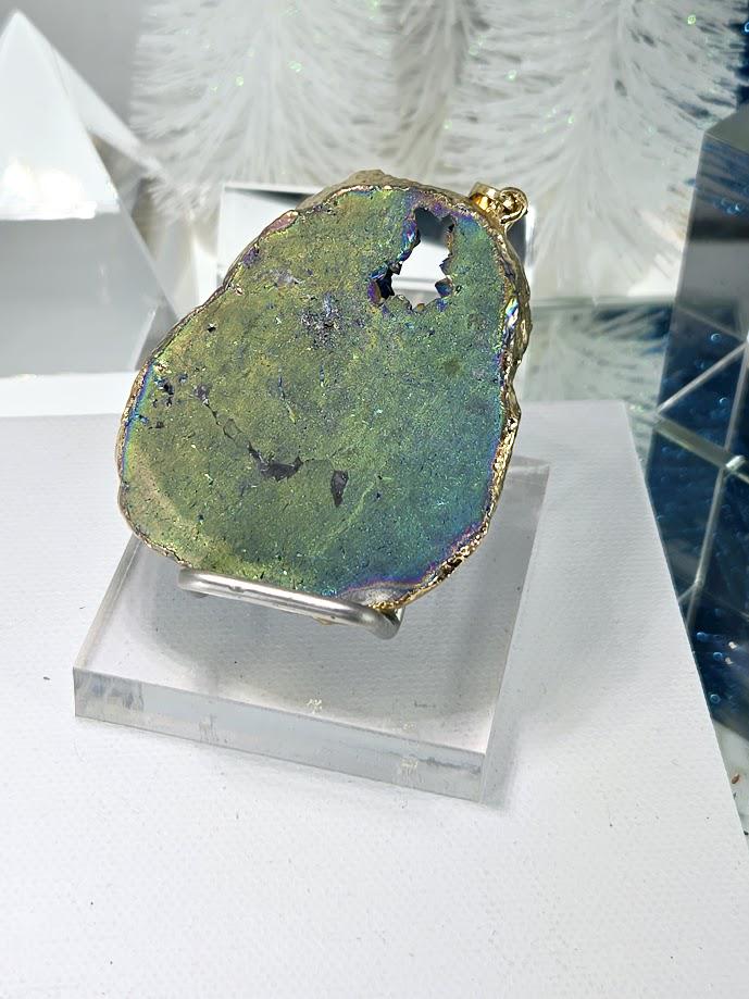 a piece of geode with a vibrant green and blue coloration, displayed on a clear glass stand.