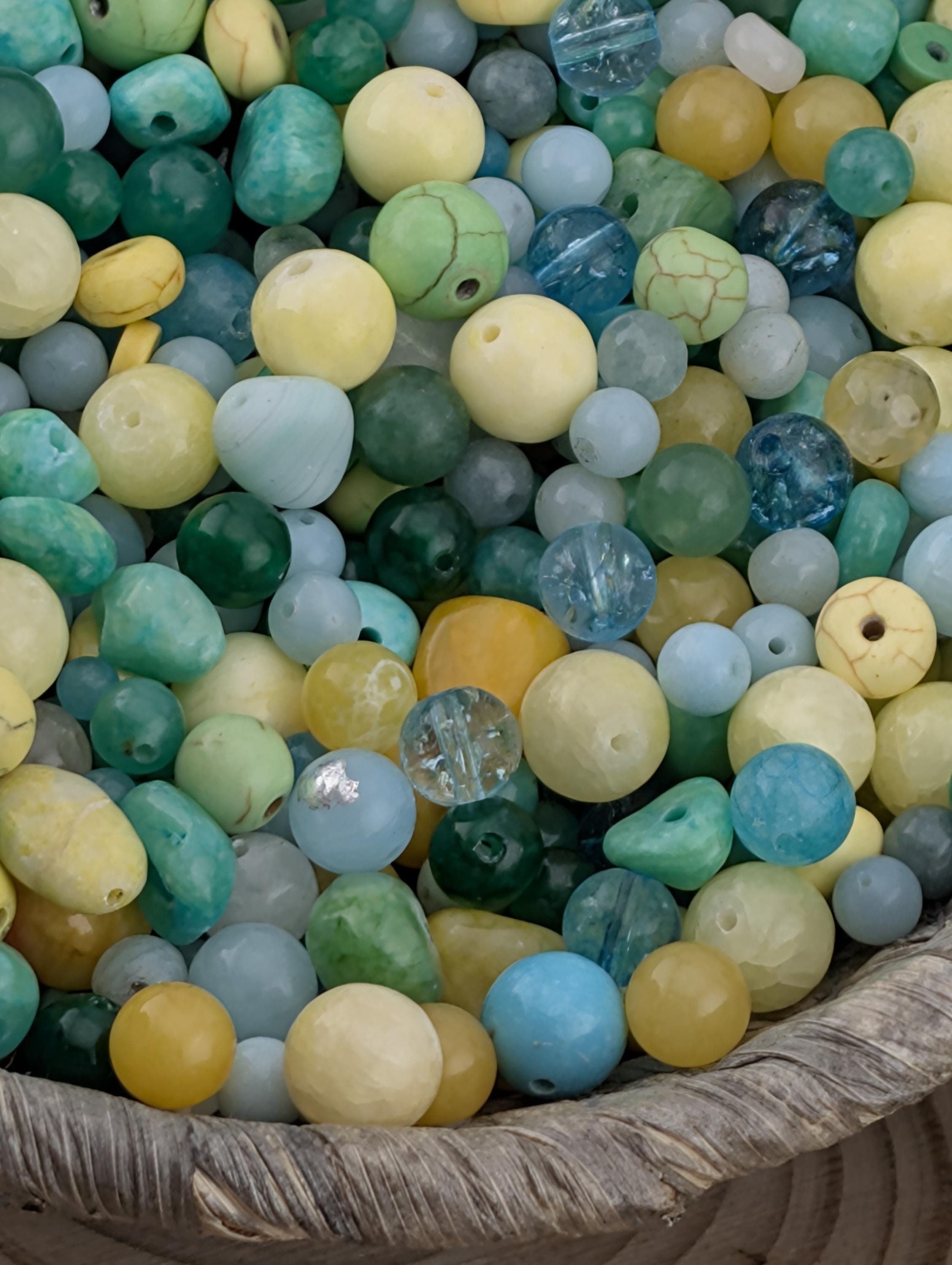 A basket filled with a variety of colorful beads, including blue, green, yellow, and white beads.