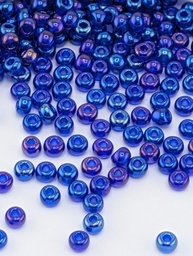 a collection of blue and purple glass beads scattered across a white background.