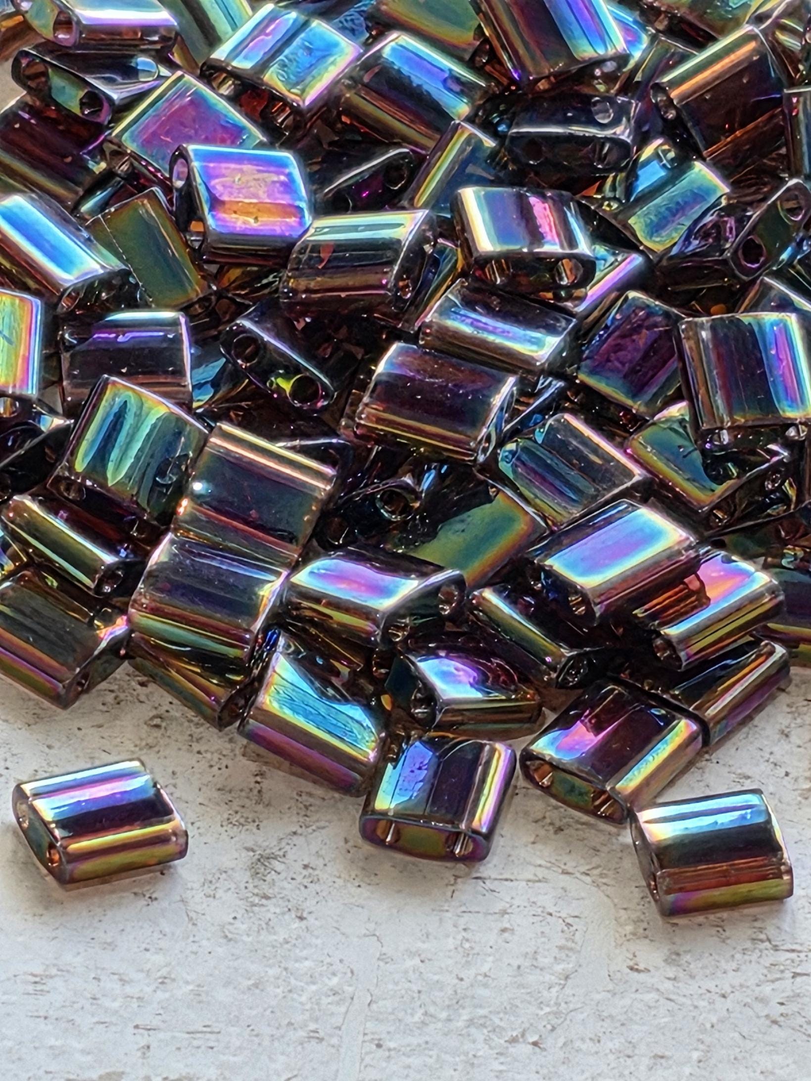 a close-up view of a pile of multicolored glass beads or glass pieces, scattered on a white surface.