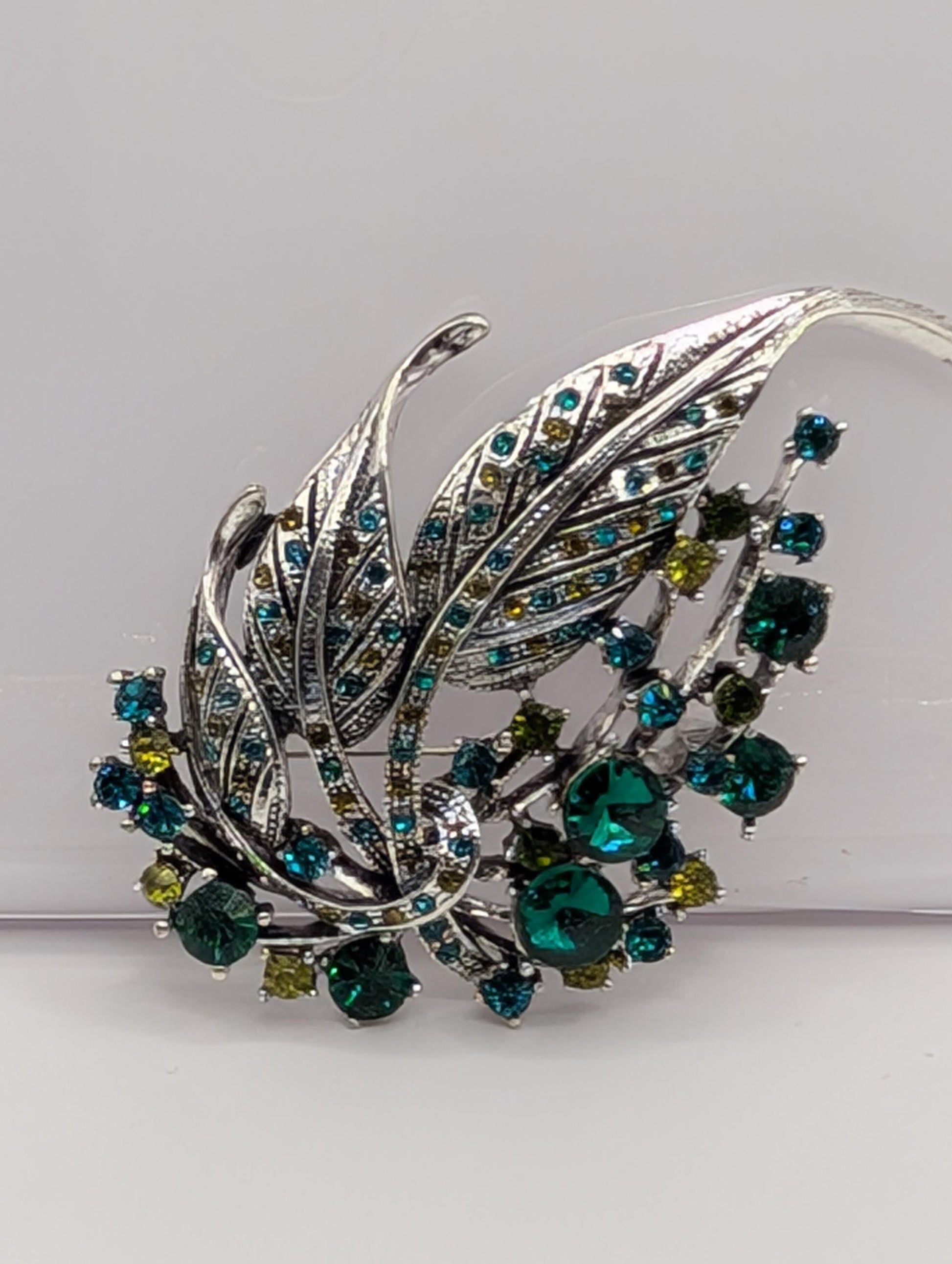Silver Feather Brooch: Blue Topaz and Emerald Accents