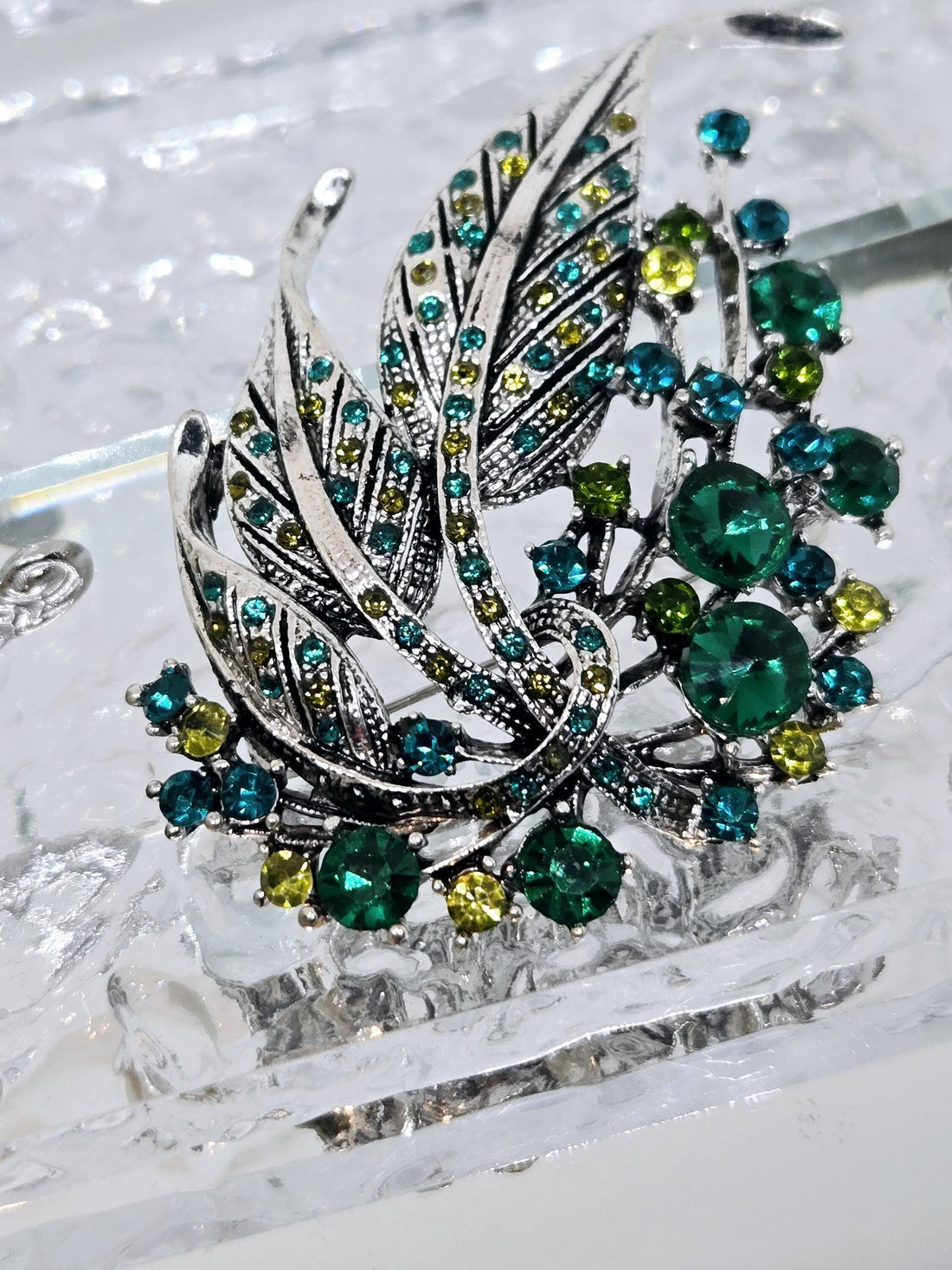 Silver Feather Brooch: Blue Topaz and Emerald Accents