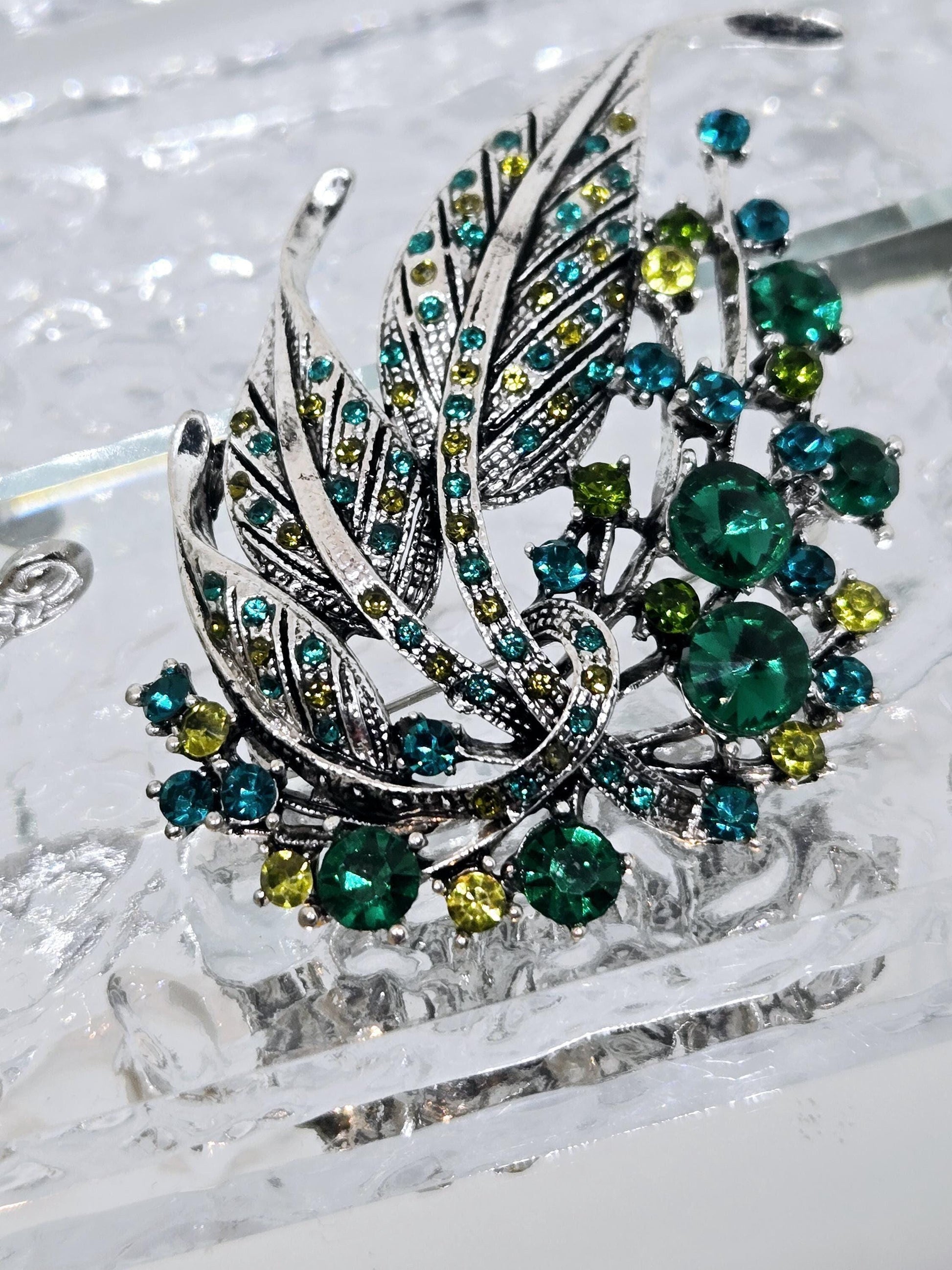 Silver Feather Brooch: Blue Topaz and Emerald Accents