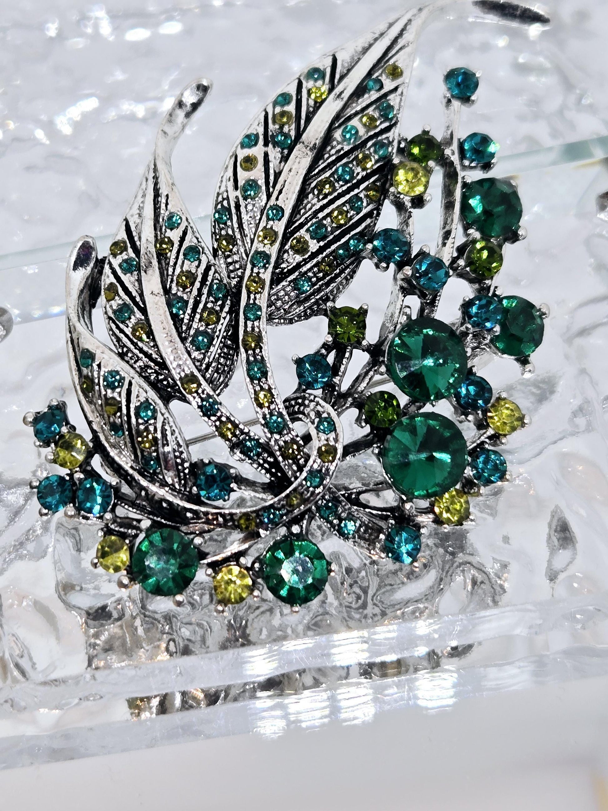 Silver Feather Brooch: Blue Topaz and Emerald Accents