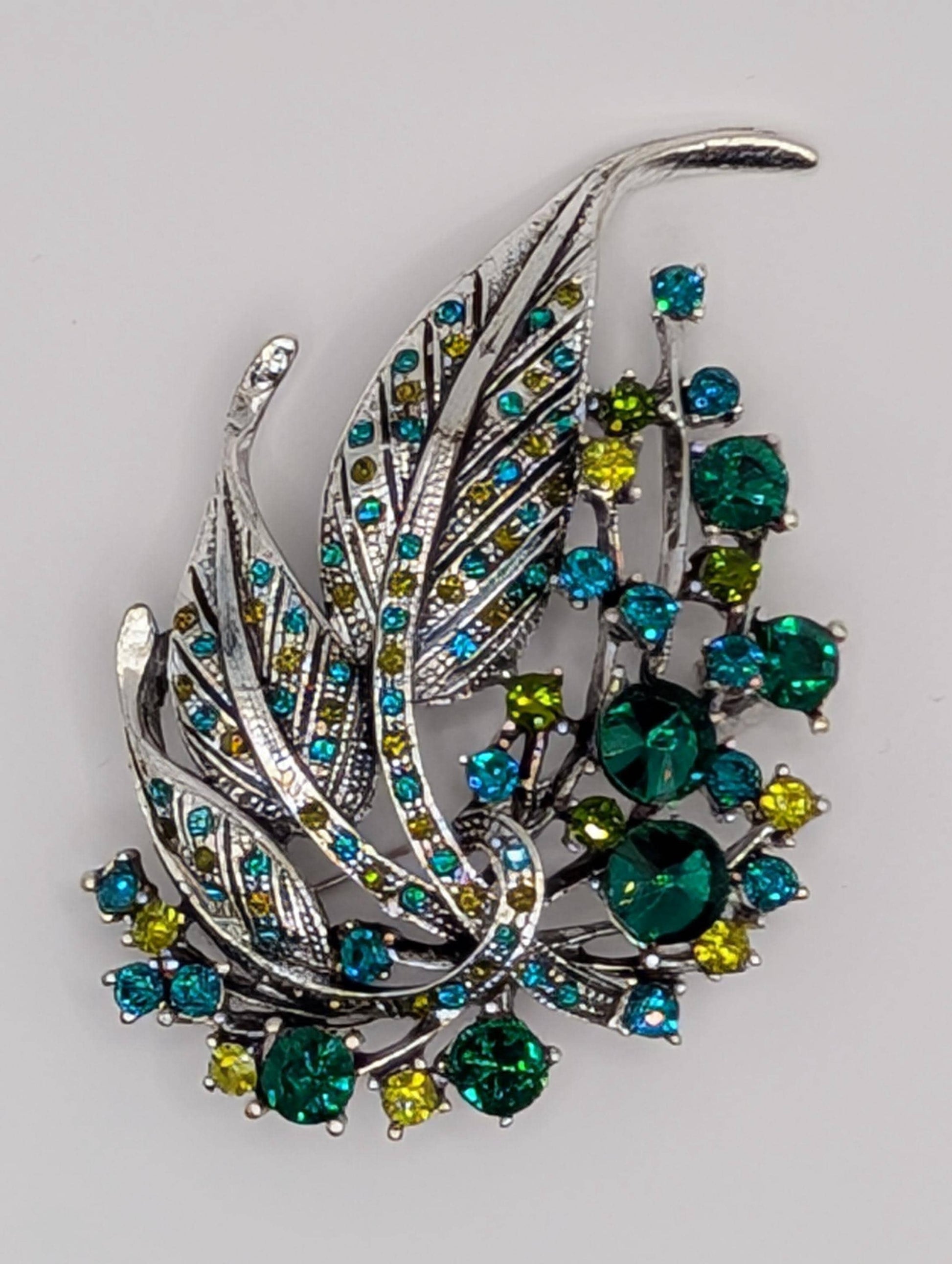 Silver Feather Brooch: Blue Topaz and Emerald Accents