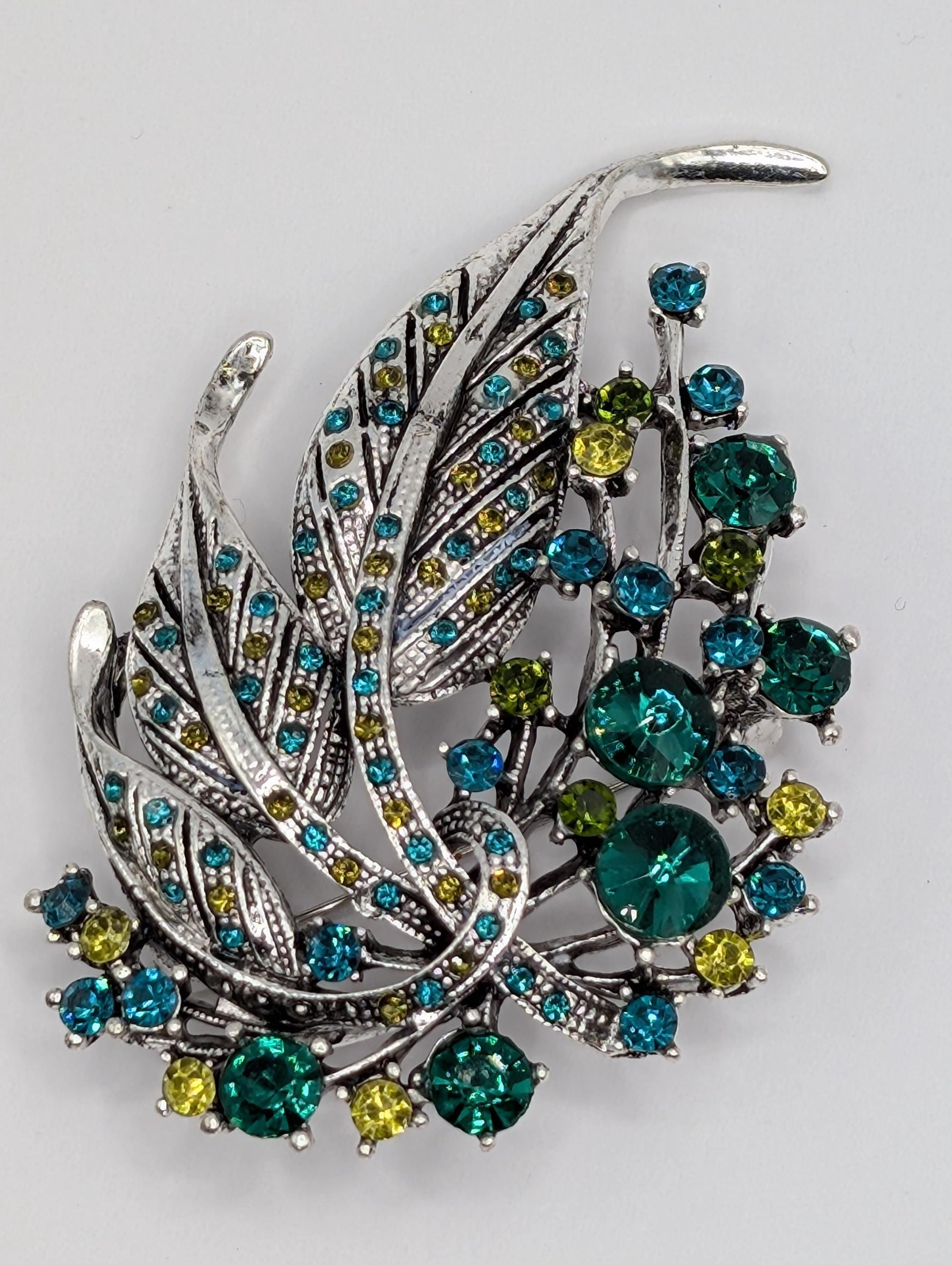 Silver Feather Brooch: Blue Topaz and Emerald Accents