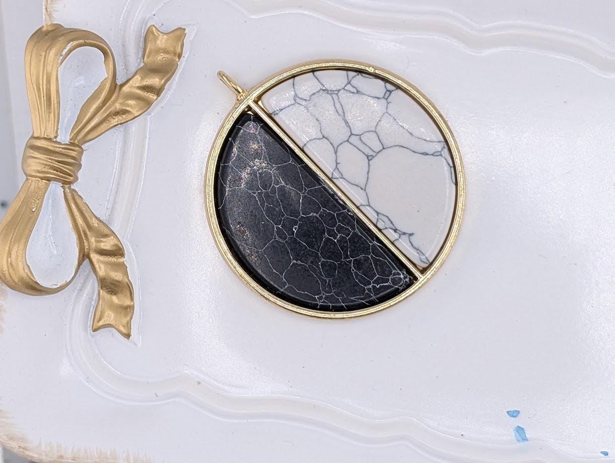 a close-up view of a decorative piece with a black and white marble design, placed on a white surface.