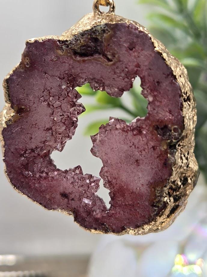 A close-up image of a large, irregularly shaped purple rock with a jagged, uneven surface.