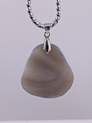 A necklace with a large, irregularly shaped stone pendant hanging from a silver chain.