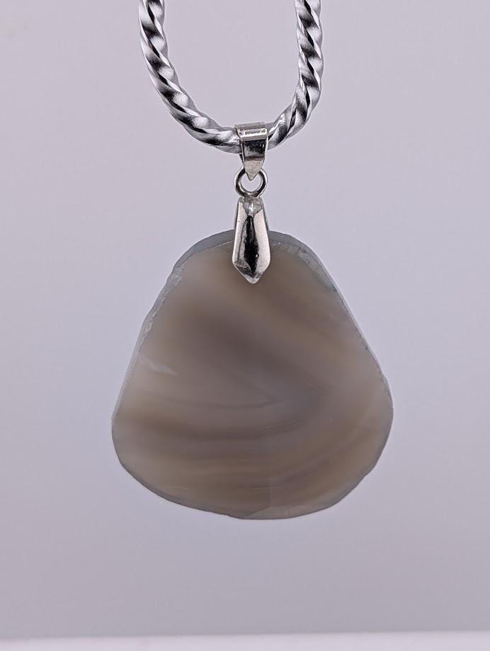A necklace with a large, irregularly shaped stone pendant hanging from a silver chain.