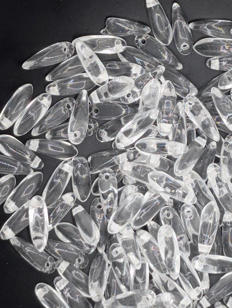 numerous clear glass beads scattered across a dark background.