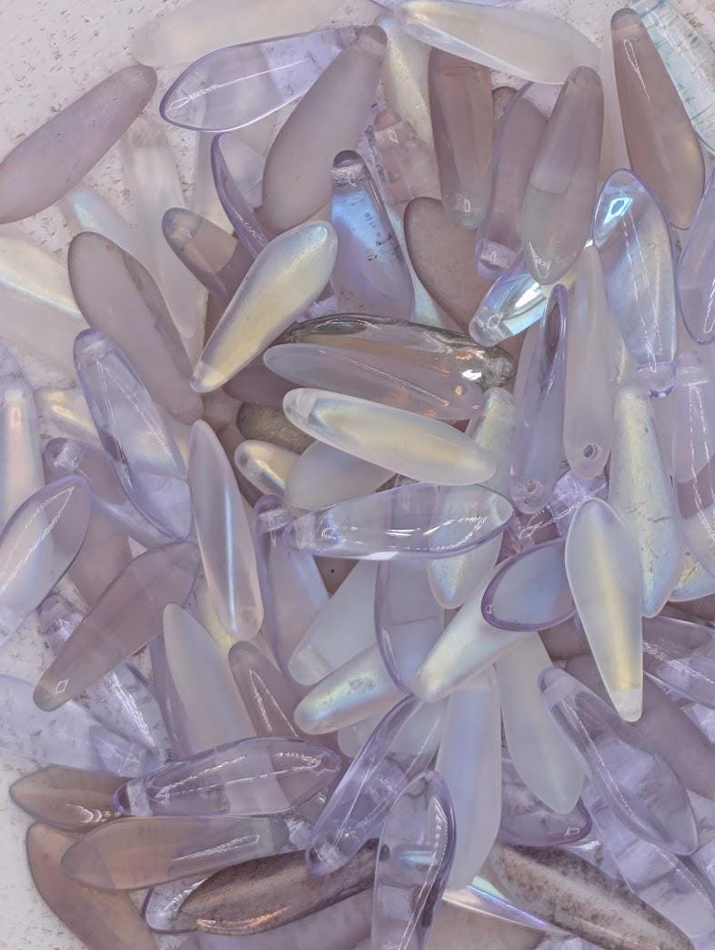 a collection of various glass beads in different shapes and sizes, scattered together.