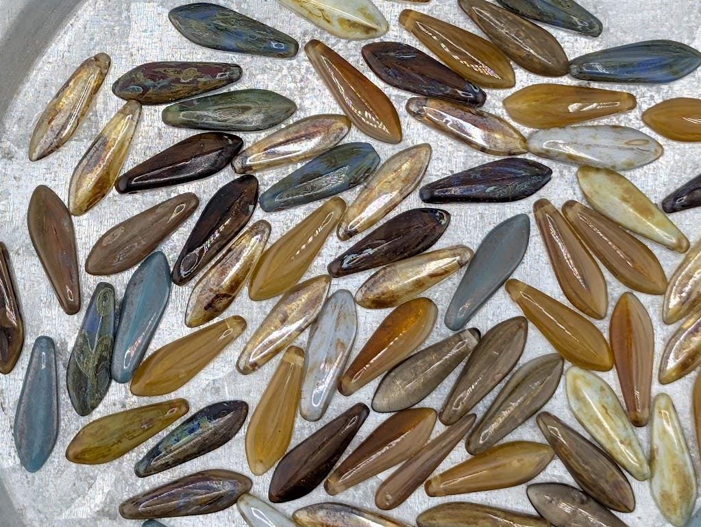 a collection of various colored glass beads or stones, including shades of brown, blue, and yellow, arranged in a visually appealing manner.