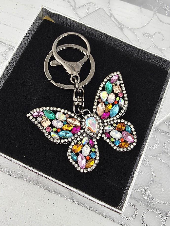 A keychain with a butterfly design, featuring a variety of colorful gemstones and sparkling rhinestones.