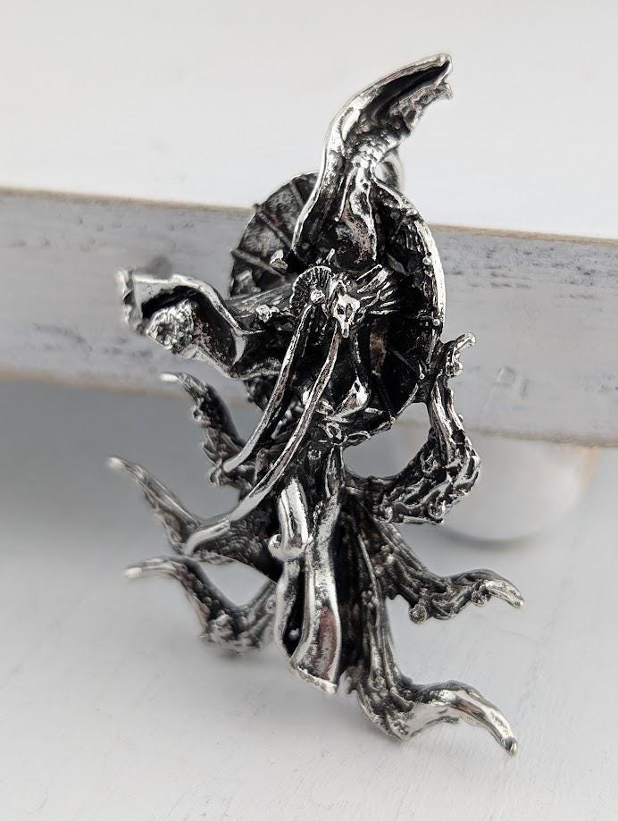 A close-up image of a silver, sculpted piece of art featuring an abstract, organic design with intricate details and textures.